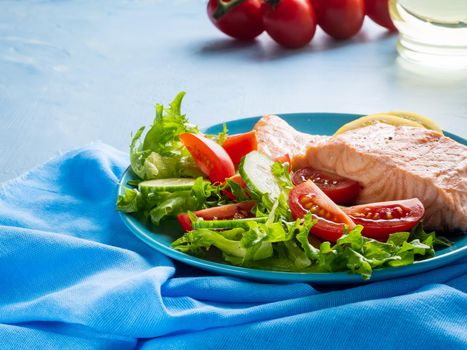 Steam salmon and vegetables, Paleo, keto, fodmap diet. Blue plate on blue table, side view, copy space