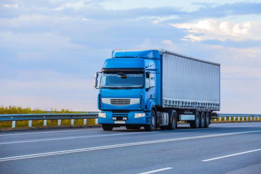 truck goes on highway in evening on sunset
