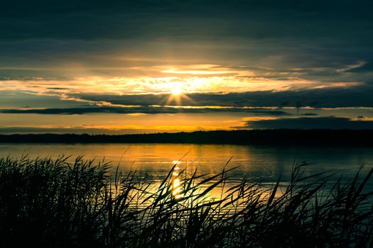 beautiful sunrise over the lake in the cloudy sky