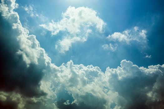 blue sky with clouds closing the sun