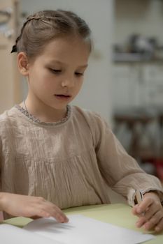 Girl is writing, make homework with beige mini chihuahua at home, white background