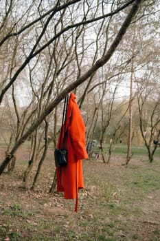 portrait of curly brunette woman in red coat in the park