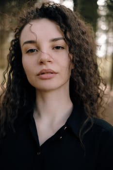 portrait of curly brunette woman in the park close up