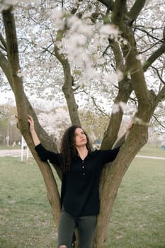 portrait of curly brunette woman in red coat in the park