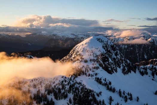 Aerial Landscape View of Coquitlam Mountain during a colorful cloudy sunset. Taken in Vancouver, British Columbia, Canada.