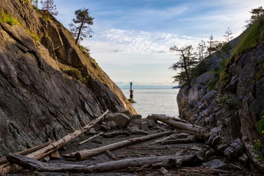 Landscape view on the logs laying on the rocky shore between the cliffs. Picture taken in Whytecliff Park, West Vancouver, British Columbia, Canada, on a beautiful sunny day.