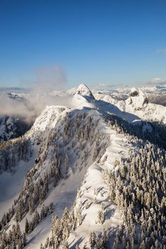 Beautiful landscape view of the snow covered mountains. Picture taken at the Vancouver North Shore, near Howe Sound, BC, Canada.