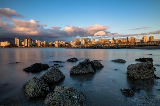 View on Downtown Vancouver during a cloudy winter sunset. Picture taken from Kits Point, British Columbia, Canada.