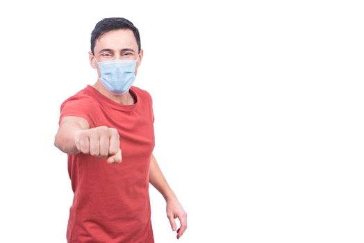 Optimistic male in t shirt and protective mask looking at camera while doing fist bump greeting isolated on white background
