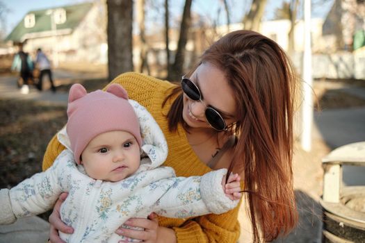 Mother holding baby smiling to camera. Real life authentic casual mom looking to camera holding infant