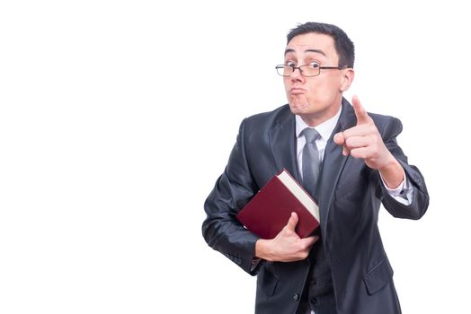 Angry male teacher in suit with book in hand pointing and looking at camera while standing isolated on white background