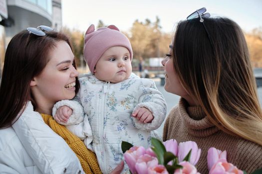 Mothers kissing their happy laughing child on both cheecks