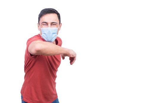 Optimistic male in medical mask looking at camera while doing greeting with elbow bump isolated on white background during coronavirus pandemic