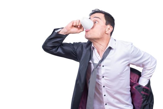 Anxious male entrepreneur drinking coffee while putting on jacket and getting ready for work isolated on white background in studio