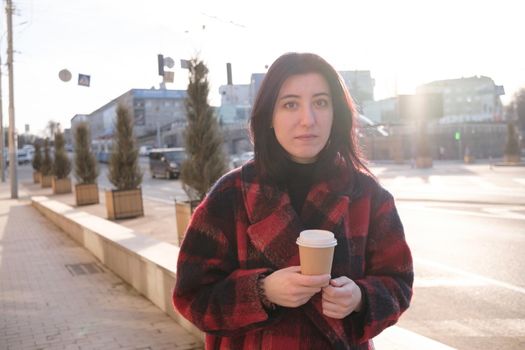 Woman drinking coffee in the sun, outdoor in sunlight light, enjoying her morning