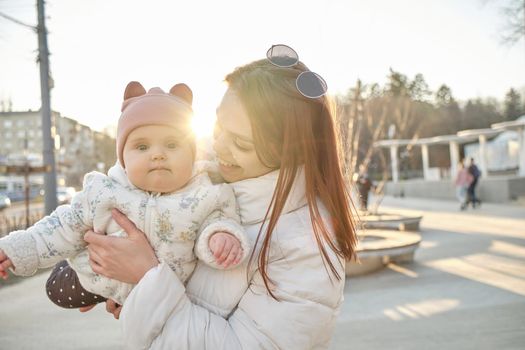 happy harmonious family outdoors. mother throws baby up, laughing and playing in the summer on the nature