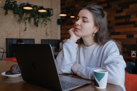 freelance woman happy working in a cafe remotely brunette