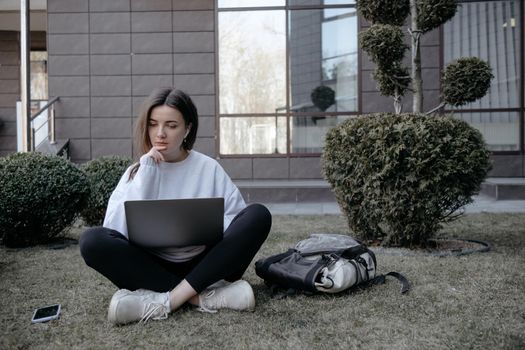 Workation outdoor. Woman working on laptop in park. Distant remote job work during quarantine coronavirus covid-19. Student studying learning online. Video blogger doing live stream.