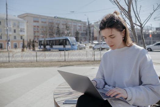 Photo of funky adorable young woman sit near fountain break from work look laptop drink coffee wear pants shirt top bag in park outdoors