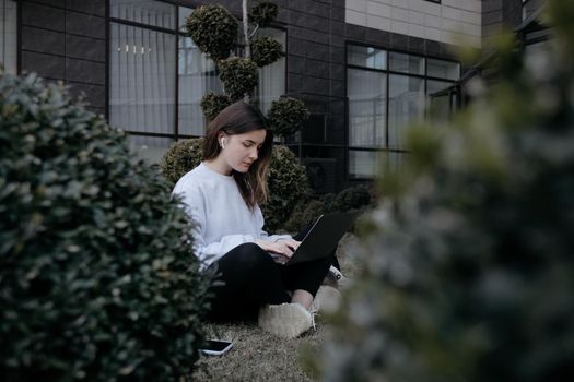 Workation outdoor. Woman working on laptop in park. Distant remote job work during quarantine coronavirus covid-19. Student studying learning online. Video blogger doing live stream.