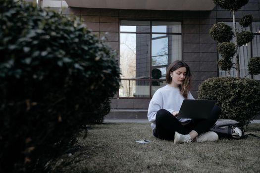 Workation outdoor. Woman working on laptop in park. Distant remote job work during quarantine coronavirus covid-19. Student studying learning online. Video blogger doing live stream.