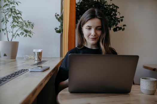 freelance woman happy working in a cafe remotely brunette