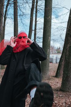 Superhero man with red mask and sunglasses fashion fighter in the park