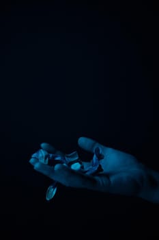 hand on a black background catches falling tulip petals