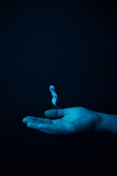 hand on a black background catches falling tulip petals