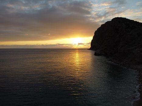 Aerial panoramic view of beautiful sunset above sea. Beautiful seascape. Sun glare, small waves on the water surface. Evening. Horizon. Nobody. No people. Copy space. Never-ending beauty of nature