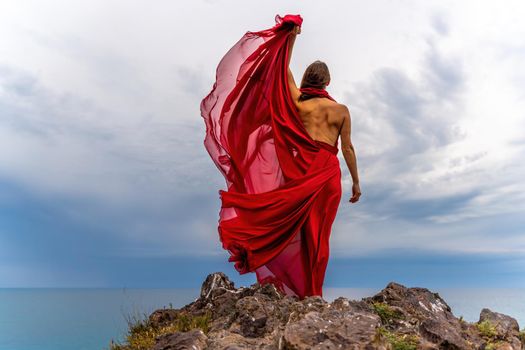 Woman in red dress dance over storm sky, gown fluttering fabric flying as splash.