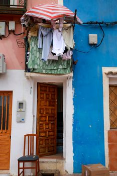 Villajoyosa, Alicante, Spain- April 22, 2022:Old colorful facades with hanging clothes in Villajoyosa, Alicante, Spain