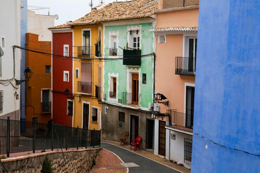 Villajoyosa, Alicante, Spain- April 22, 2022:Narrow cobbled street and beautiful colorful facades in Villajoyosa village, Alicante, Spain