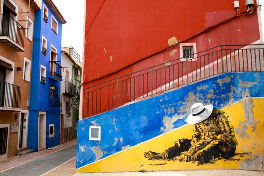 Villajoyosa, Alicante, Spain- April 22, 2022:Beautiful mural on the wall and Old colorful facades in Villajoyosa, Alicante, Spain