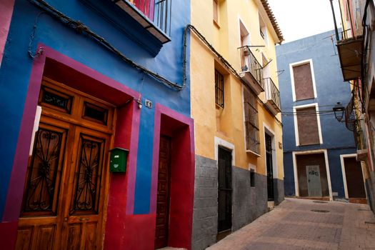 Villajoyosa, Alicante, Spain- April 22, 2022:Narrow cobbled street and beautiful colorful facades in Villajoyosa village, Alicante, Spain