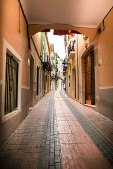 Villajoyosa, Alicante, Spain- April 22, 2022:Narrow cobbled street and beautiful colorful facades in Villajoyosa village, Alicante, Spain