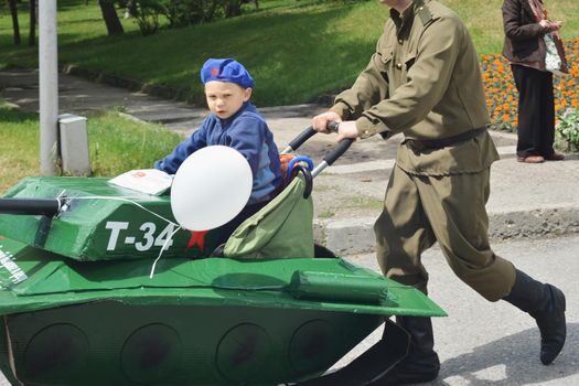 PYATIGORSK, RUSSIA - MAY 09, 2017: A little boy in artificial tank at a parade