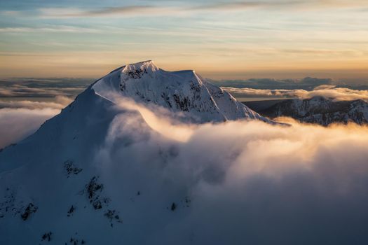 Aerial Landscape View Mt Wrottesley covered in snow during a beautiful sunset. Picture taken North of Vancouver near Howe Sound, BC, Canada.