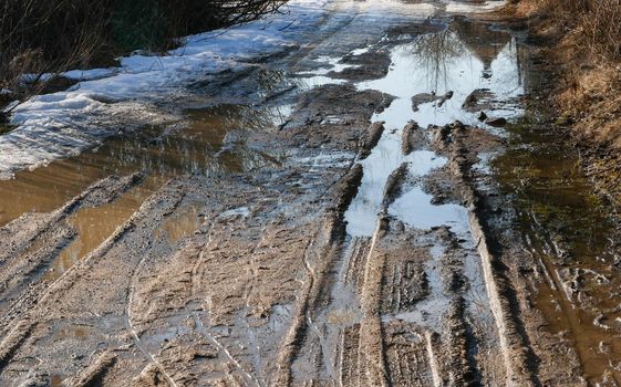 Broken village road with traces of passing cars.