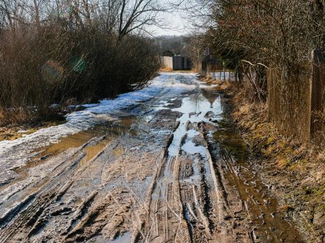 Broken village road with traces of passing cars.