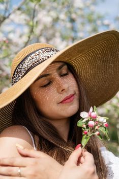 Spring concept. Nature. Portrait of young caucasian woman enjoying the flowering of an apple trees, walking in spring apple gardens