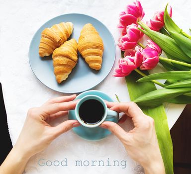 Girl with croissants and coffee, a bouquet of pink tulips, happy morning.