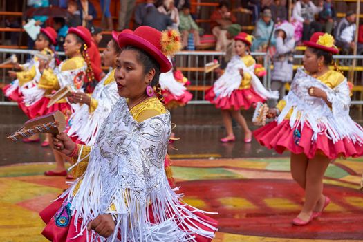 ORURO, BOLIVIA - FEBRUARY 25, 2017: Female Morenada dancers in colourful costumes parading through the mining city of Oruro on the Altiplano of Bolivia during the annual Oruro Carnival.