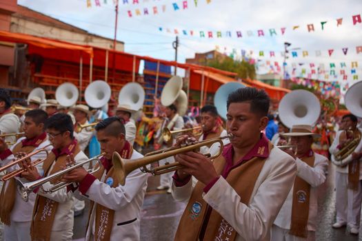 ORURO, BOLIVIA - FEBRUARY 25, 2017: Band of a Morenada dance group in colourful outfits parading through the mining city of Oruro on the Altiplano of Bolivia during the annual Oruro Carnival.