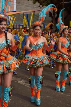 ORURO, BOLIVIA - FEBRUARY 25, 2017: Female Morenada dancers in colourful costumes parading through the mining city of Oruro on the Altiplano of Bolivia during the annual Oruro Carnival.