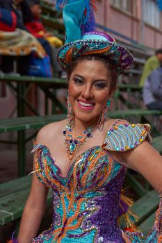 ORURO, BOLIVIA - FEBRUARY 25, 2017: Female Morenada dancers in colourful costumes parading through the mining city of Oruro on the Altiplano of Bolivia during the annual Oruro Carnival.