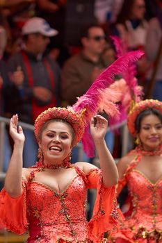 ORURO, BOLIVIA - FEBRUARY 25, 2017: Female Morenada dancers in colourful costumes parading through the mining city of Oruro on the Altiplano of Bolivia during the annual Oruro Carnival.