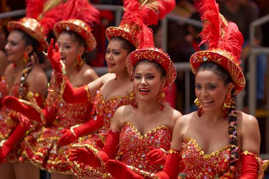 ORURO, BOLIVIA - FEBRUARY 25, 2017: Female Morenada dancers in colourful costumes parading through the mining city of Oruro on the Altiplano of Bolivia during the annual Oruro Carnival.