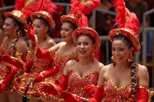 ORURO, BOLIVIA - FEBRUARY 25, 2017: Female Morenada dancers in colourful costumes parading through the mining city of Oruro on the Altiplano of Bolivia during the annual Oruro Carnival.