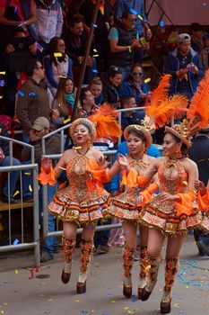 ORURO, BOLIVIA - FEBRUARY 25, 2017: Female Morenada dancers in colourful costumes parading through the mining city of Oruro on the Altiplano of Bolivia during the annual Oruro Carnival.